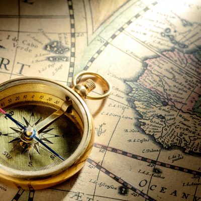 Antique compass on ancient map
