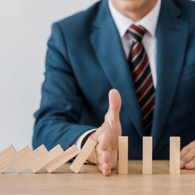 close up of businessman with blocks wood game in office, insurance concept
